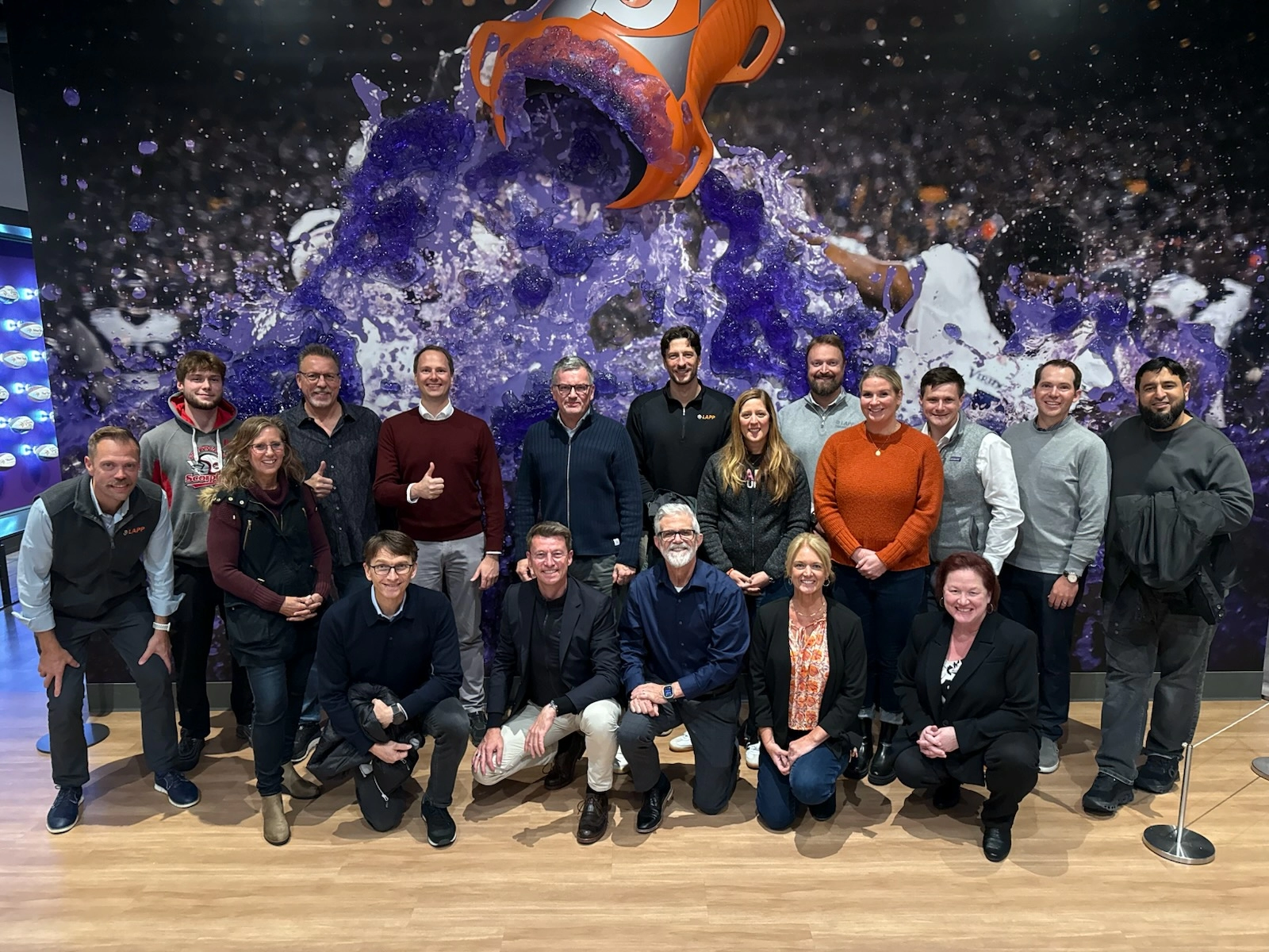Tannehill and LAPP employees posing in front of a mural at the Minnesota Vikings Museum